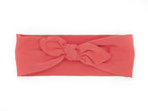 A handmade orange top knot headband for babies from By Bella Boutique.